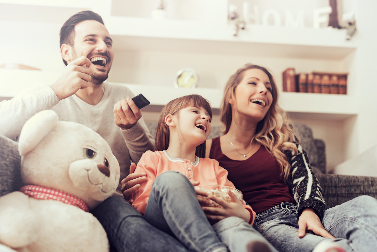 Familia disfrutando televisión en casa